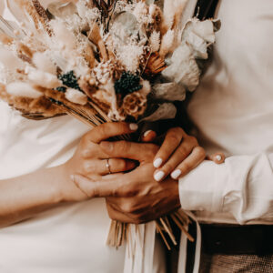 The bride and groom holds in her hands a beautiful bouquet of dried flowers in the style of boho